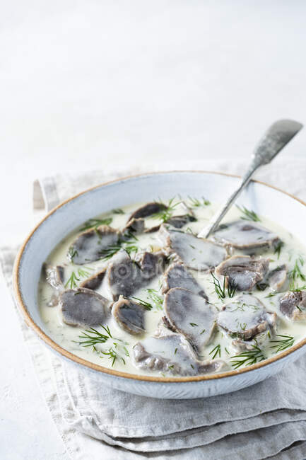 Bowl of Turkey stomachs in dill sauce with spoon — Stock Photo