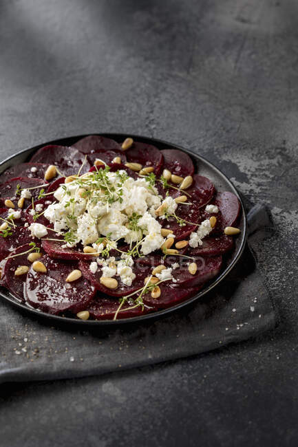 Beetroot with goats cheese, pine nuts, cress, olive oil, salt and pepper — Stock Photo
