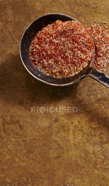Briciole e spezie in cucchiaio su superficie rustica — Foto stock