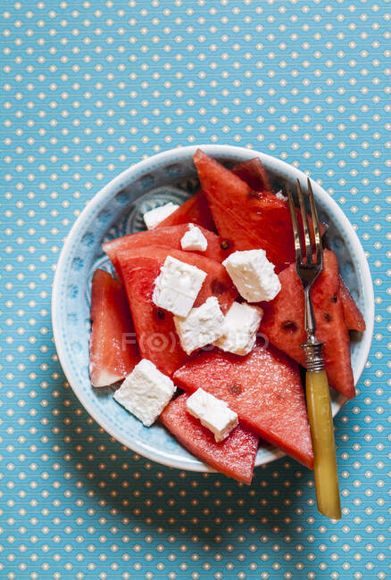 Servieren von Wassermelone und Feta-Käsesalat in Schüssel mit Messer — Stockfoto