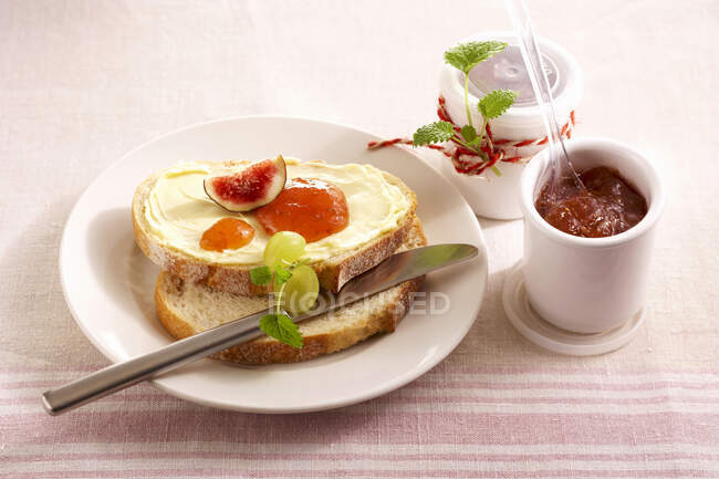 Marmellata di uva e fichi sul pane imburrato con una tazza di caffè — Foto stock