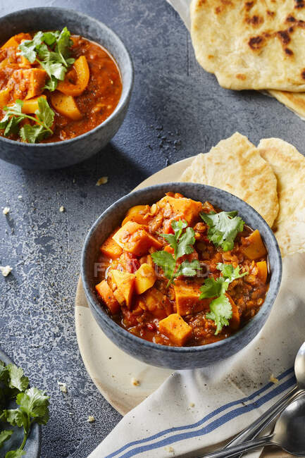 Sweet potatoes with potatoes, lentils and tomatoes, with flat bread — Stock Photo