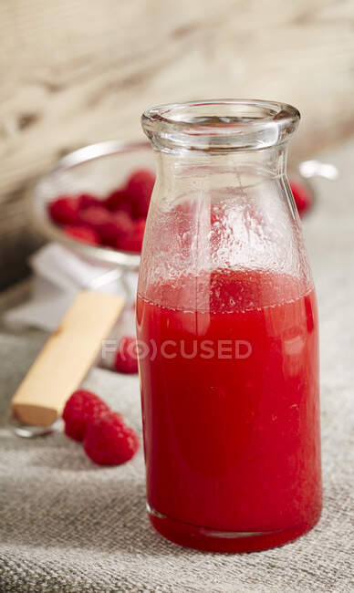 Homemade raspberries liqueur with vodka in glass bottle — Stock Photo