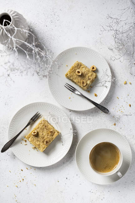Gluten-free blondie with hazelnut served on white plates with coffee — Stock Photo