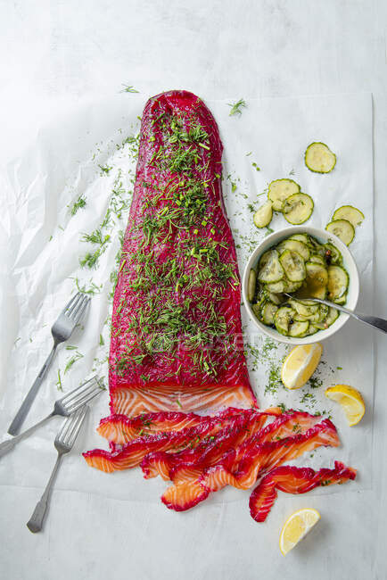 Gravlax, marinated salmon fillet with fresh dill and pickled cucumber salad — Stock Photo