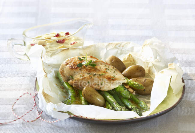Asparagi con petto di pollo e patate in carta pergamena — Foto stock