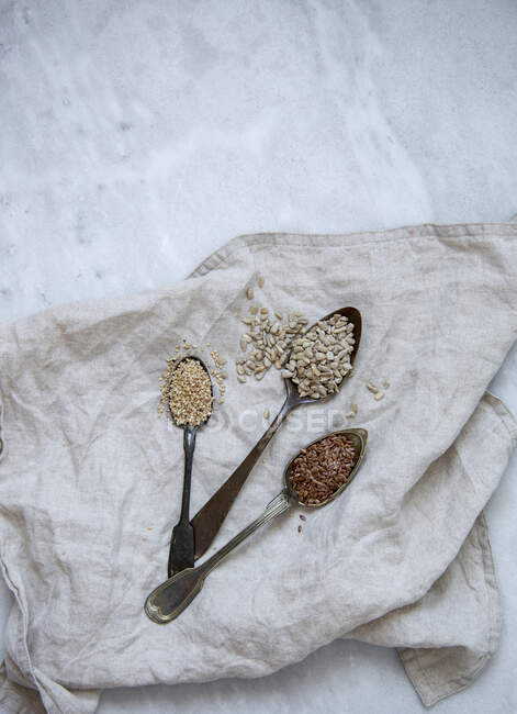 Sesamo, girasole, semi di lino su fondo di marmo — Foto stock