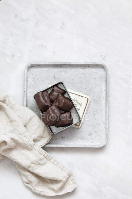 Chocolate candy with nuts and dates in gift box on white marble background — Fotografia de Stock