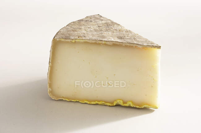 Pieza de queso de oveja duro sobre fondo blanco con sombra - foto de stock