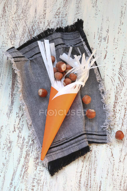 Ein Orangenkegel gefüllt mit Haselnüssen — Stockfoto