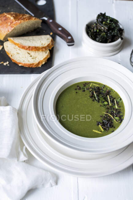 Суп зі шпинату, прикрашений сочевицею, капустяними чіпсами, пасером та лимонною цедрою — стокове фото