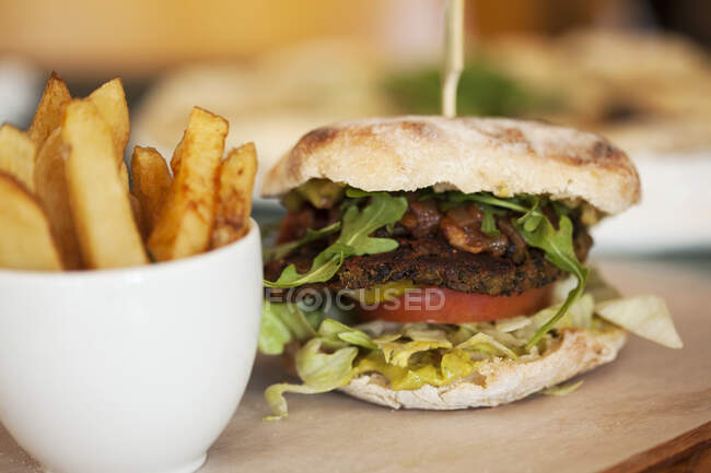 Вегетарианский бургер с черной фасолью и картофельными клиньями — стоковое фото