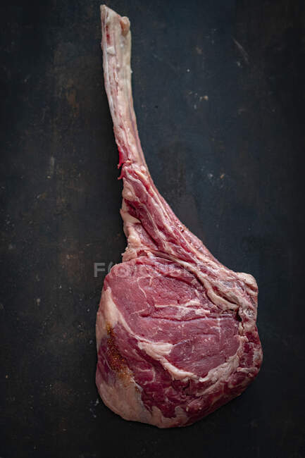 Raw tomahawk steak on black background — Stock Photo