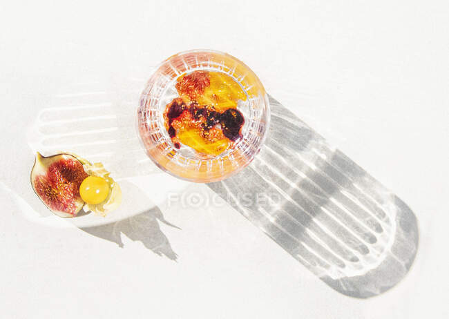 Cóctel de verano con higo y puré de physalis en una sombra de fundición de vidrio - foto de stock