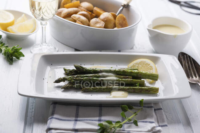 Grilled green asparagus with vegan Sauce Hollandaise with mini roast potatoes — Stock Photo