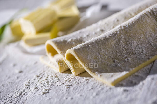 Puff pastry with flout on a wooden surface — Stock Photo