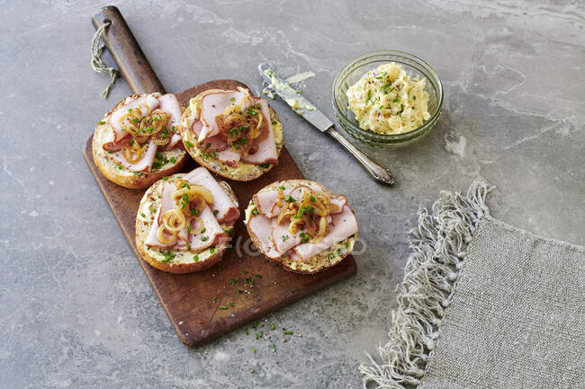 Rolls topped with Leberkse, beef and pork meatloaf with chive, onion and mustard butter in a jar — Stock Photo