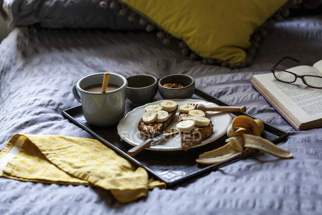 Café da manhã na cama com chá, mel, manteiga de amendoim e torrada — Fotografia de Stock