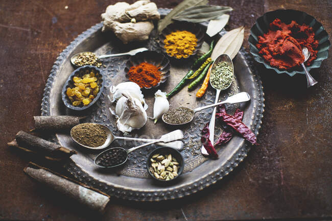 Various spices and sultanas on a metal plate — Stock Photo