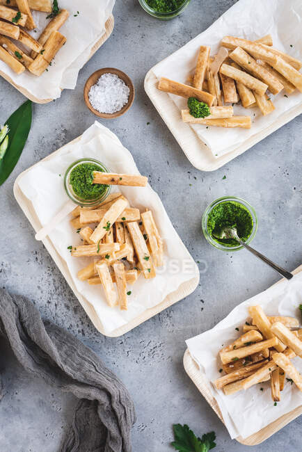 Cassava fries with wild garlic salsa verde in bamboo bowls — Stock Photo