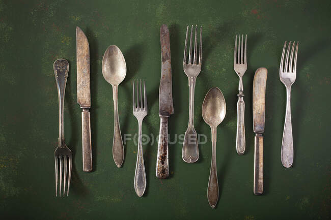 Vintage silver cutlery on green surface — Stock Photo