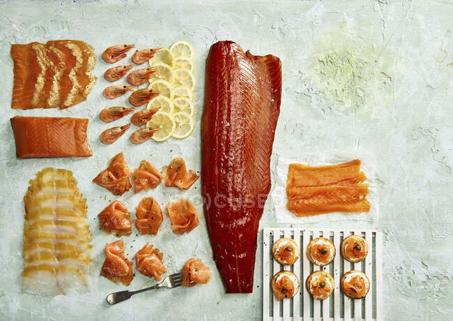 Variedad de pescado ahumado: salmón ahumado, gambas, eglefino y blini - foto de stock