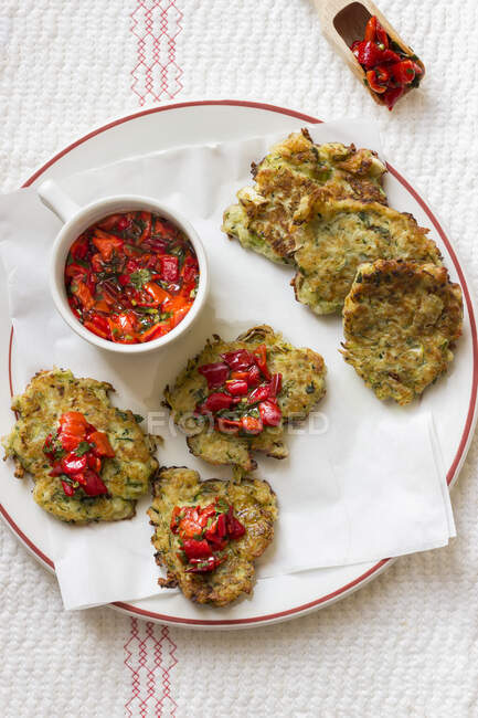 Halloumi and zucchini fritters with red pepper and parsley salsa — Stock Photo