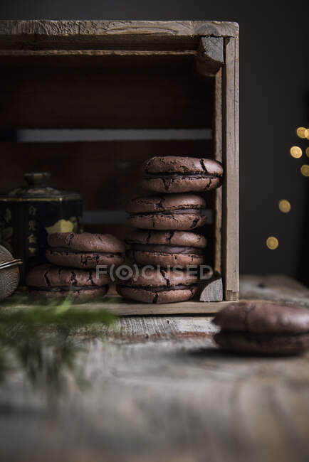 Cracked chocolate macaroons in wooden box — Stock Photo