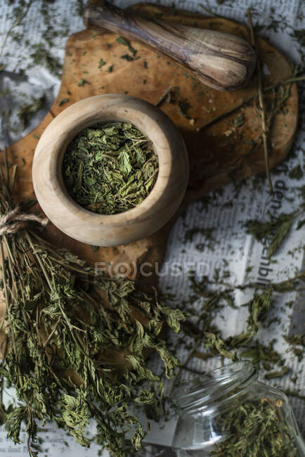 Dried mint on a wooden surface and in a wooden mortar — Stock Photo