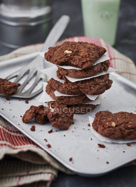 Chocolate cookies with baking paper on tray with metal paddle — Stock Photo