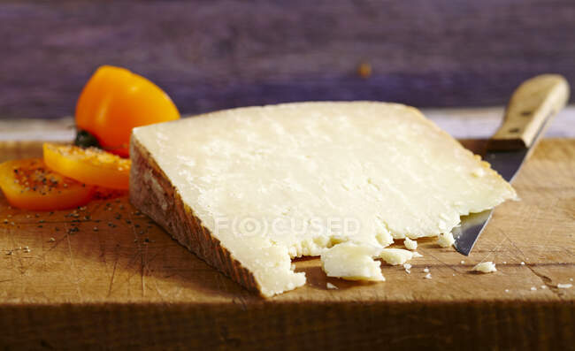 Pecorino sardo sheep's cheese on wooden board with a knife — Stock Photo