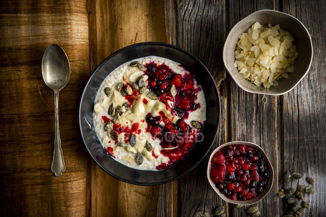 Porridge with almond butter, whiskey candied pumpkin seeds berries — Stock Photo