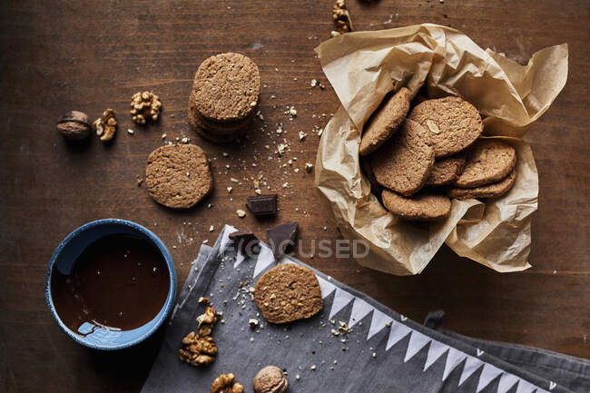 Walnut cookies and melted chocolate in bowl — Stock Photo
