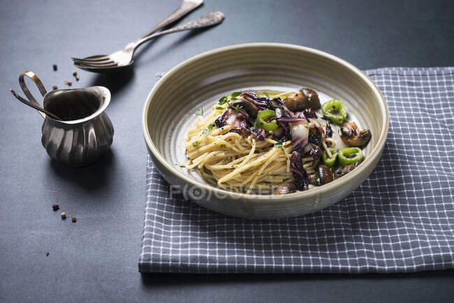 Espaguetis con radicchio frito, champiñones y pimientos - foto de stock