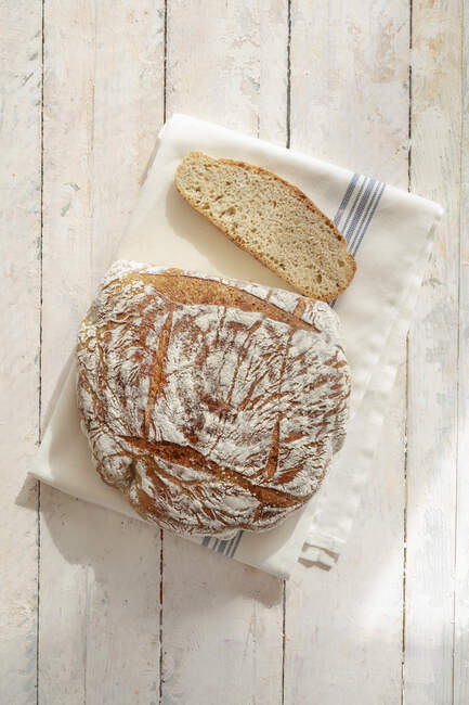 Pão de espelta pão com fatia em pano na superfície de madeira rústica — Fotografia de Stock