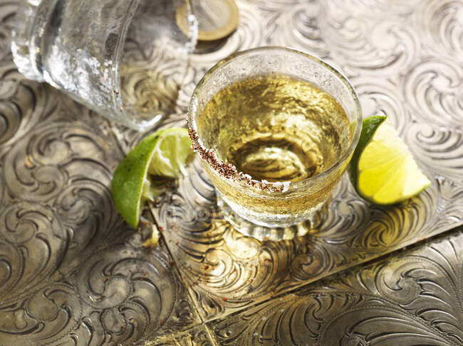 Primer plano de delicioso tiro de tequila con cuñas de lima - foto de stock