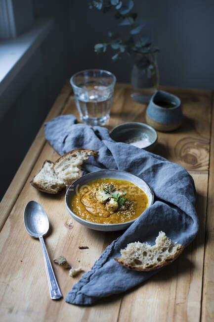 Carrot soup with roasted cauliflower served with bread — Stock Photo