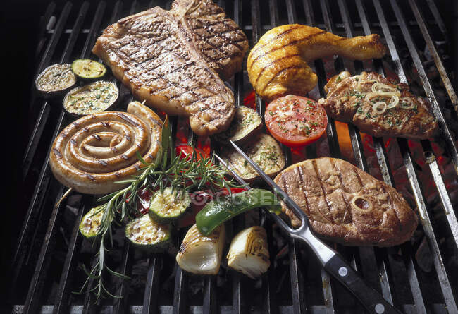 Meat, poultry and vegetables on a grill grate — Stock Photo