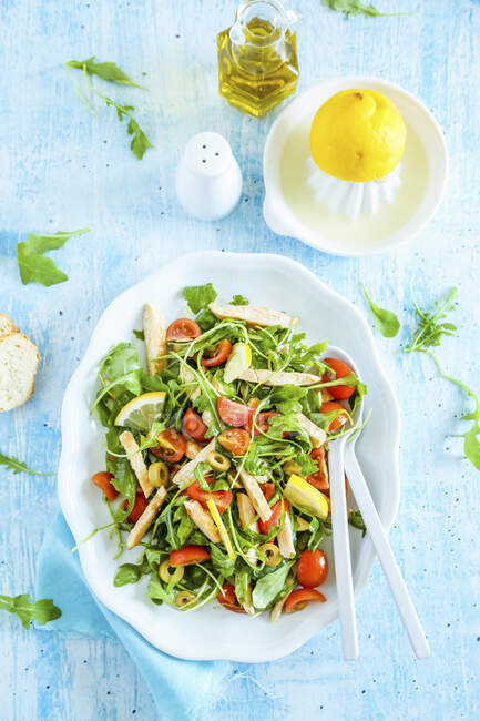 Fresh chicken salad with rocket olives cherry tomatoes and lemon — Stock Photo