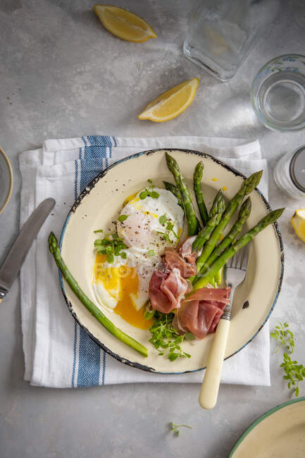 Green asparagus with poached egg and parma ham — Stock Photo