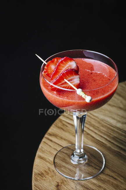 Strawberry margarita with berry slices on stick on glass — Stock Photo