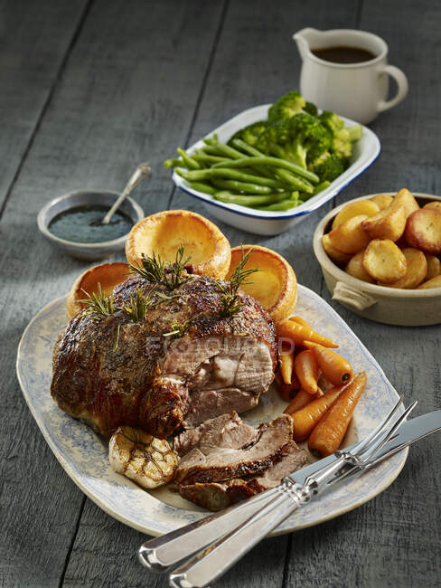 Roasted leg of lamb with Yorkshire puddings and vegetables (England) — Stock Photo