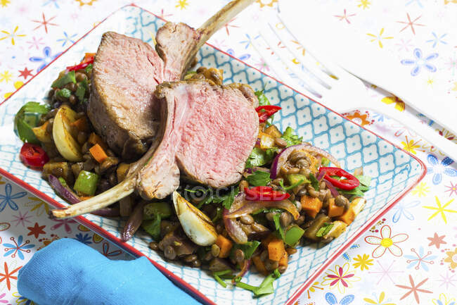 Rare lamb chops on a lentil medley with fresh chillis — Stock Photo