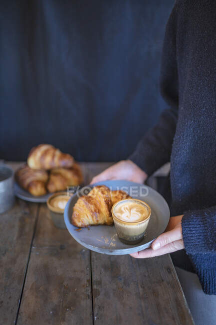 Croissants com um cappuccino em uma chapa — Fotografia de Stock
