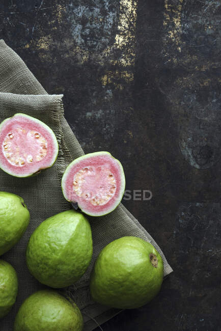 Close-up de deliciosas goiabas, inteiras e cortadas pela metade — Fotografia de Stock