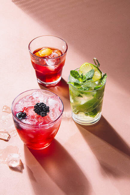 Mojito, Negroni and Bramble cocktails on pink background — Stock Photo
