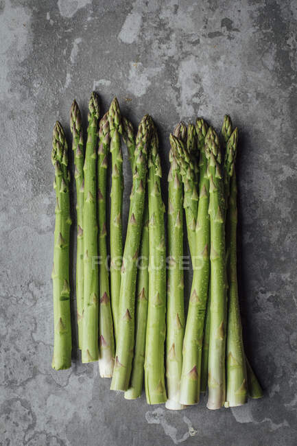 Green asparagus on cement background — Stock Photo