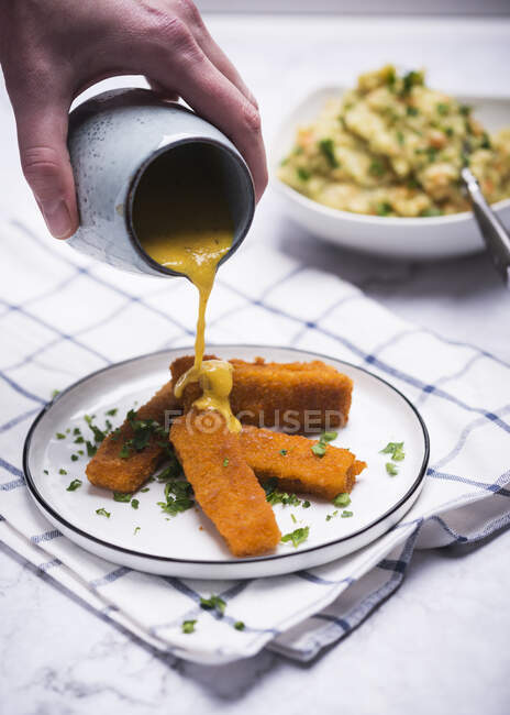 'Dedos de pescado' veganos hechos de proteína de soja con una salsa de hierbas cremosa - foto de stock