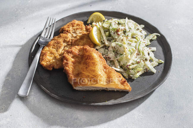 Chicken schnitzel with cabbage salad and fork — Stock Photo