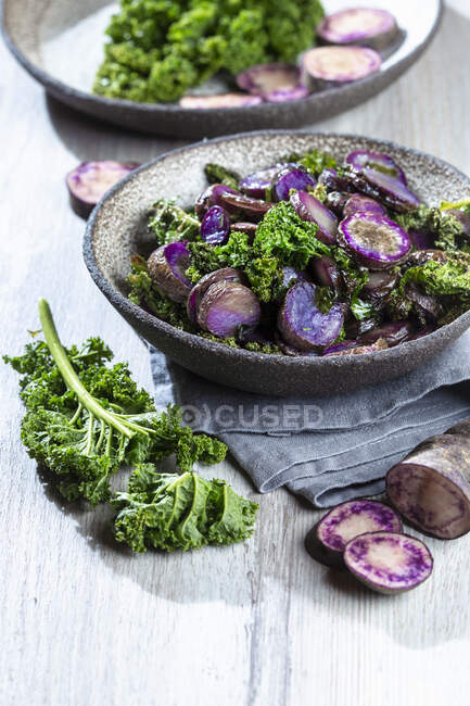 Baked purple potatoes with kale — Stock Photo